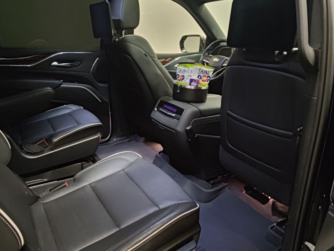 The second row of a Cadillac Escalade ESV with the rear door open, showing legroom