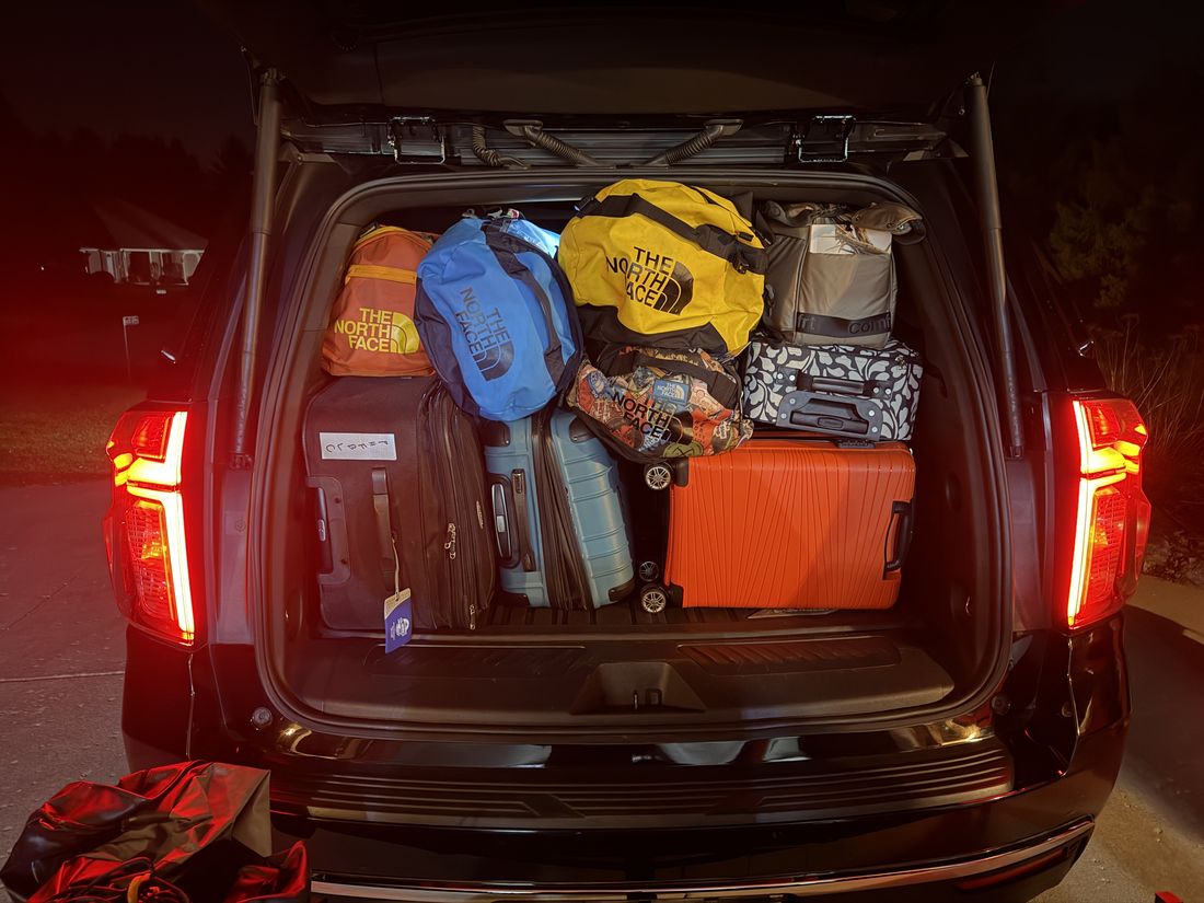 The same cargo area loaded with luggage, tailgate open at dusk