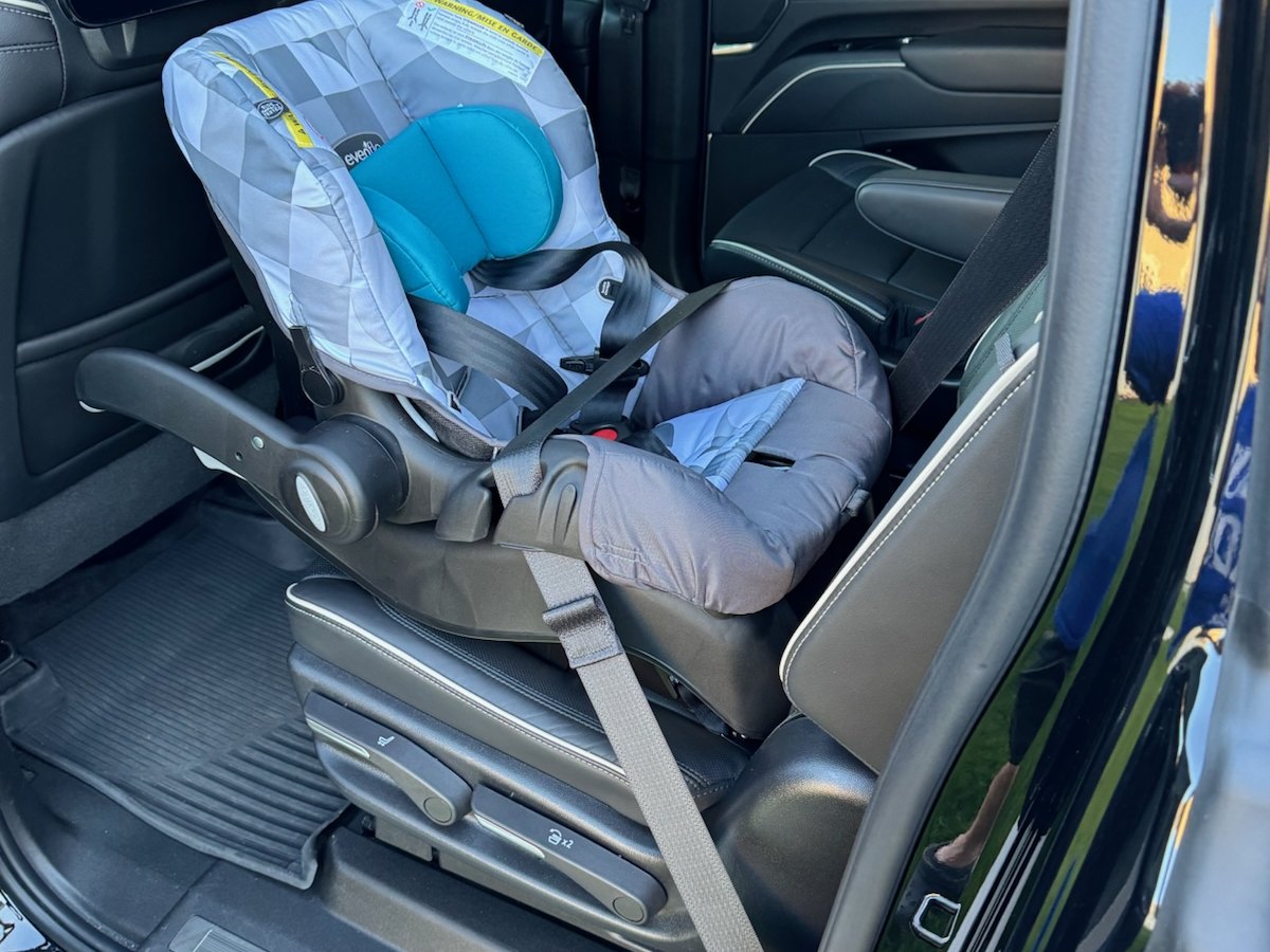 An infant seat installed in a Cadillac Escalade ESV with the rear door open