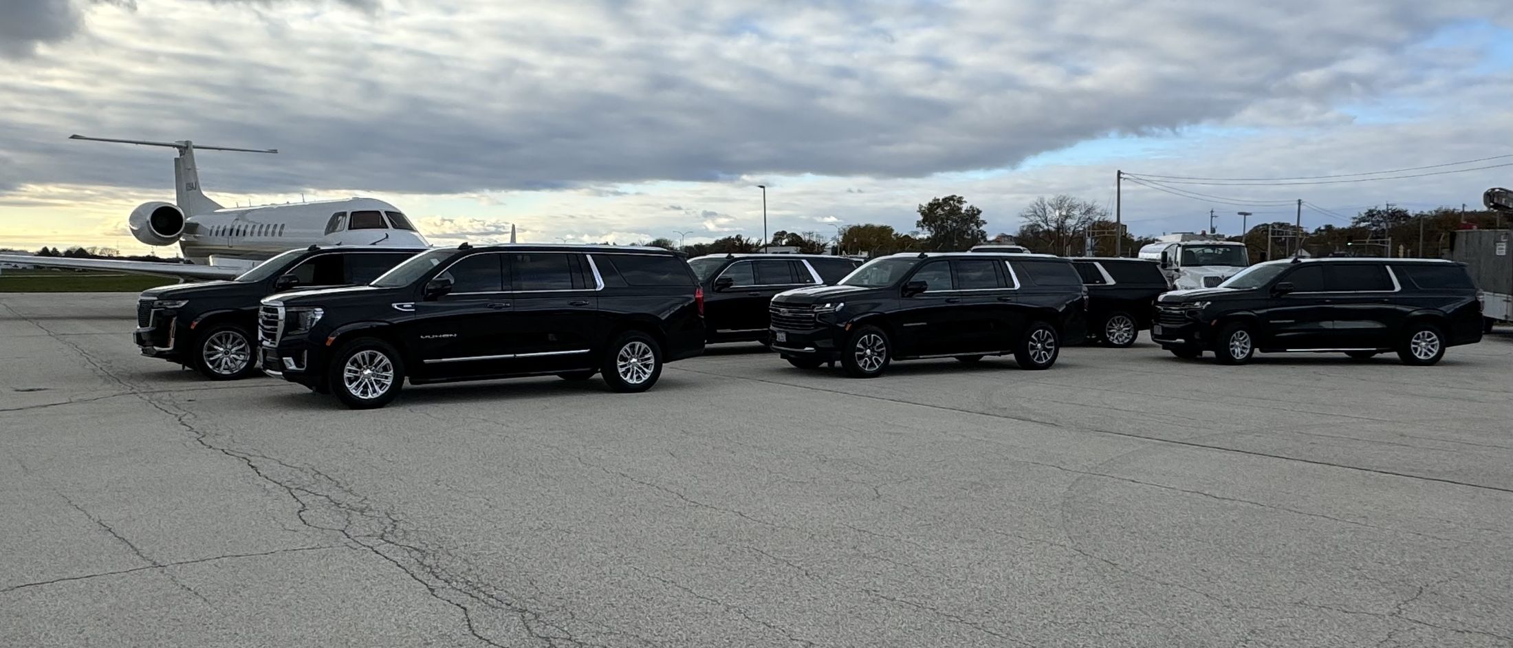 Black SUVs lined up on a private aviation ramp, the kind of arrival we meet at Waukesha County Airport