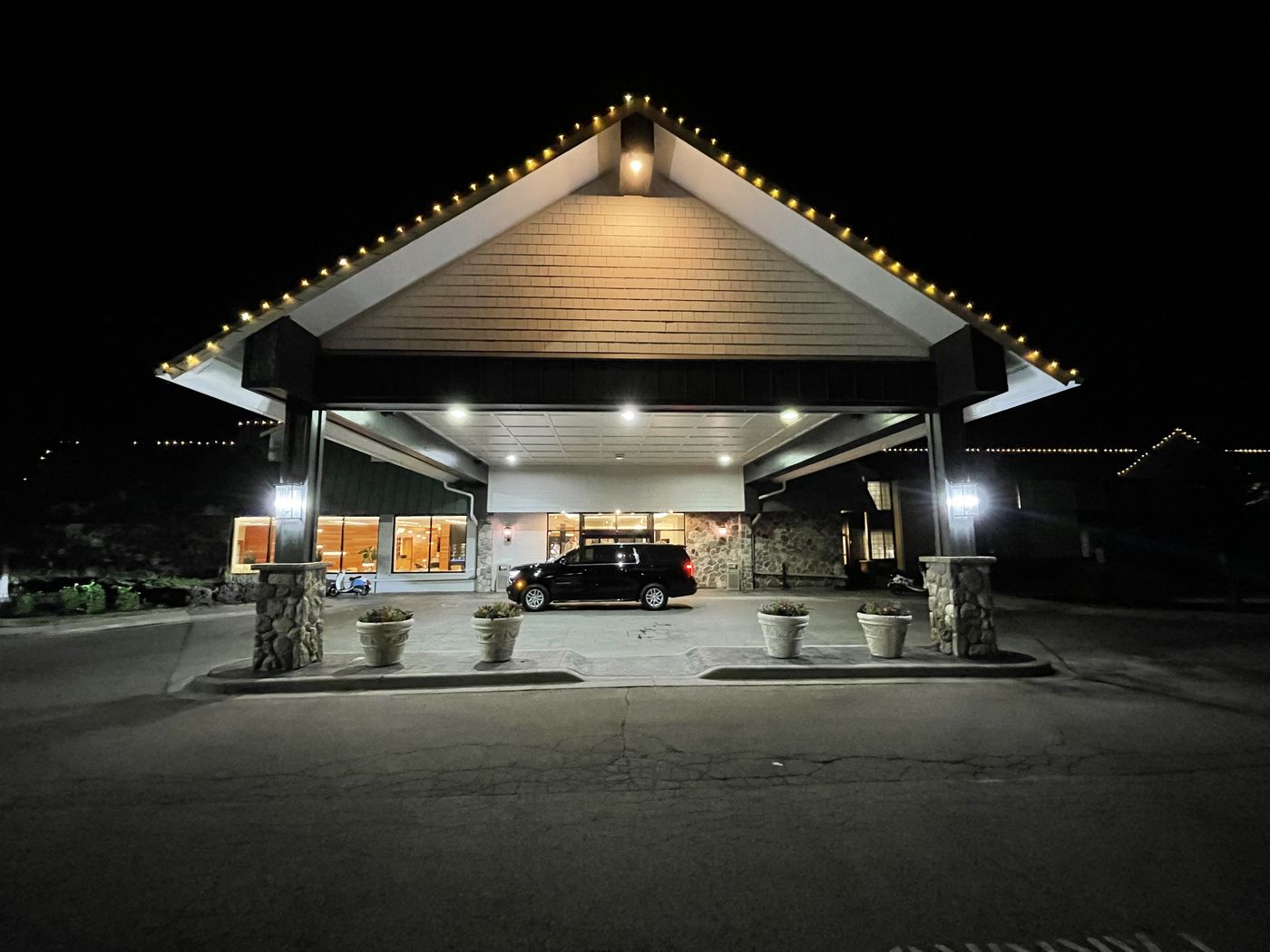 Black SUV under the lit porte-cochere of a Lake Geneva resort at night