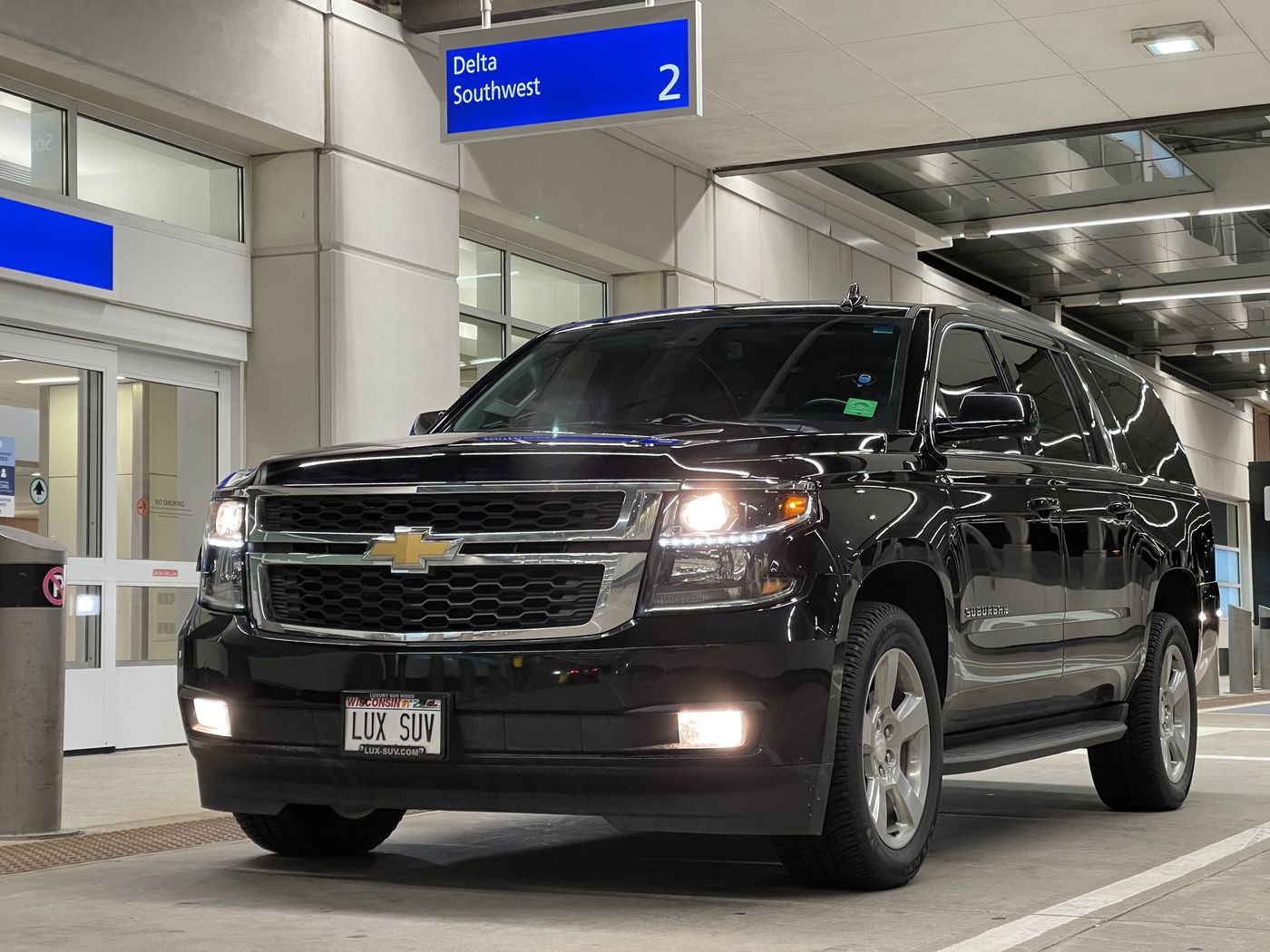 Black Chevrolet Suburban at the airline curb at Milwaukee Mitchell International Airport, the closest airport to Shorewood