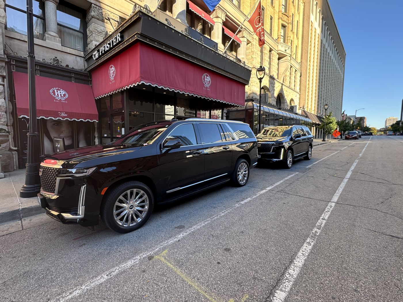 Black Cadillac Escalade ESV waiting at the entrance of The Pfister Hotel on East Wisconsin Avenue in downtown Milwaukee